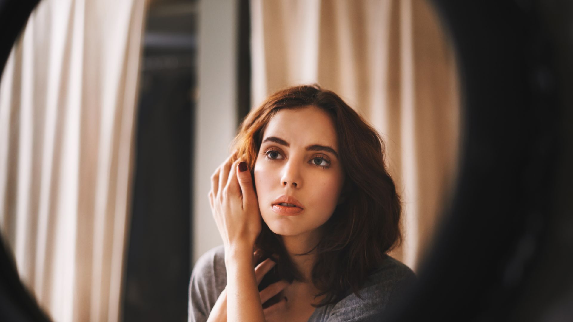 Imagem do reflexo de uma mulher se olhando no espelho