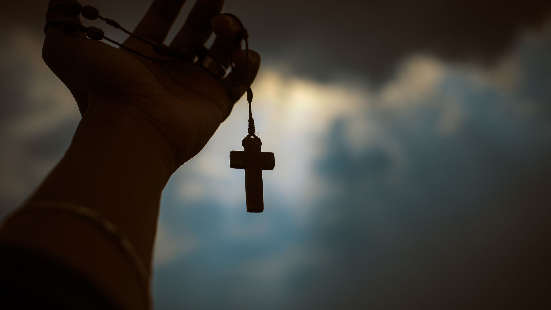 Gift Habeshaw de Pexels grátis para o Canva Pro Imagem de uma mão segurando uma cruz de madeira.
