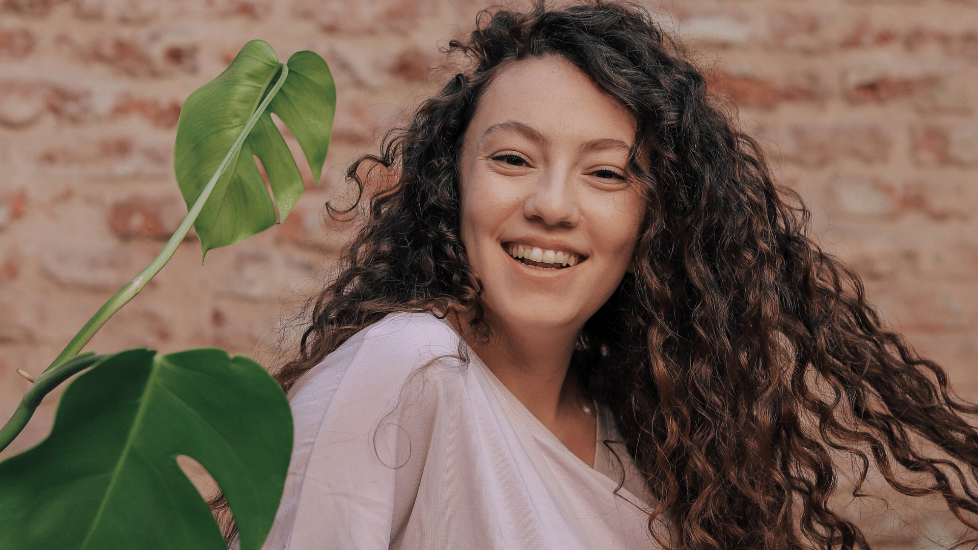 Mensagens Com Amor / Canva / Farshad sheikhzad de Pexels Foto de uma mulher sorrindo e olhando para frente.
