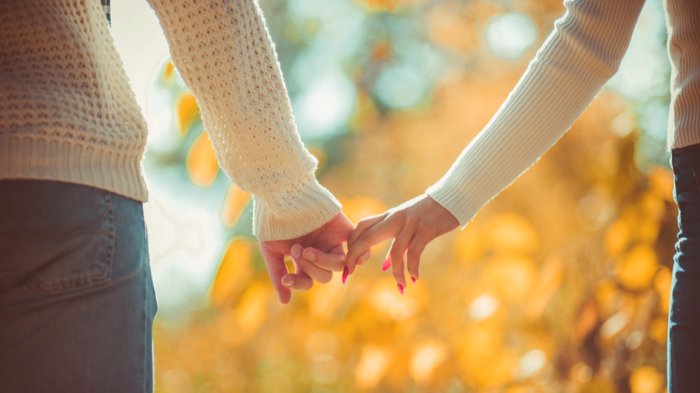 Gorgev / Shutterstock Casal segurando a mão um do outro apenas com as pontas dos dedos.