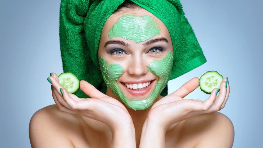 Mulher aplicando máscara skin care verde