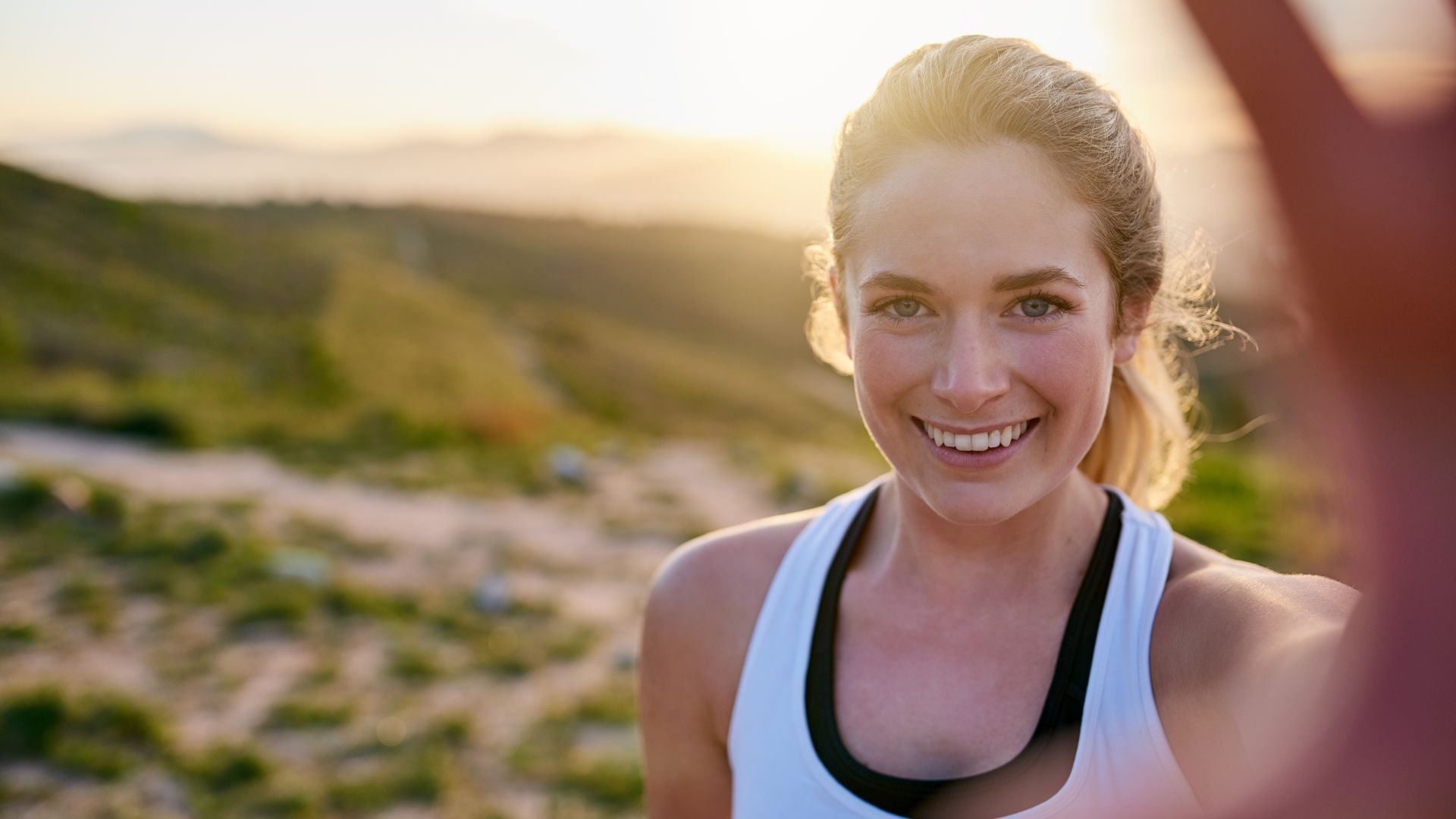 Mensagens Com Amor / Canva / PeopleImages de Getty images Signature Imagem de uma mulher olhando para frente e sorrindo