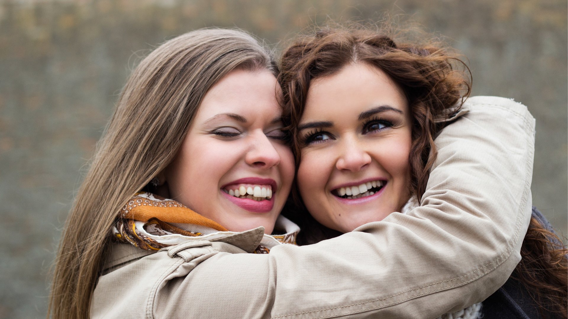Duas mulheres se abraçando e sorrindo