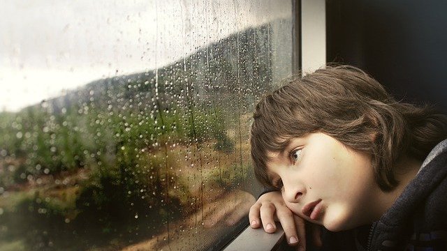 Free-Photos / Pixabay Menino olhando chuva pela janela