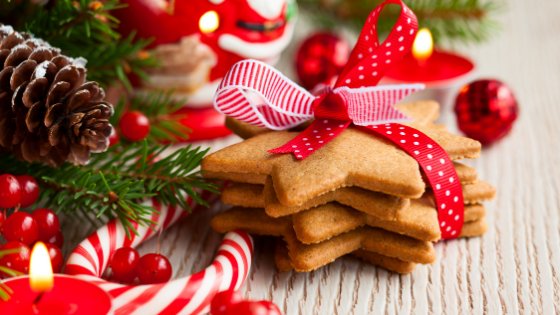 Biscoitos de Natal com laço ao lado de enfeites de natal