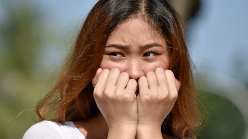 Mulher jovem com feição de insegura.