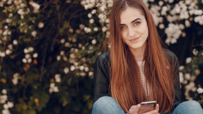 Mulher segurando o celular e sorrindo