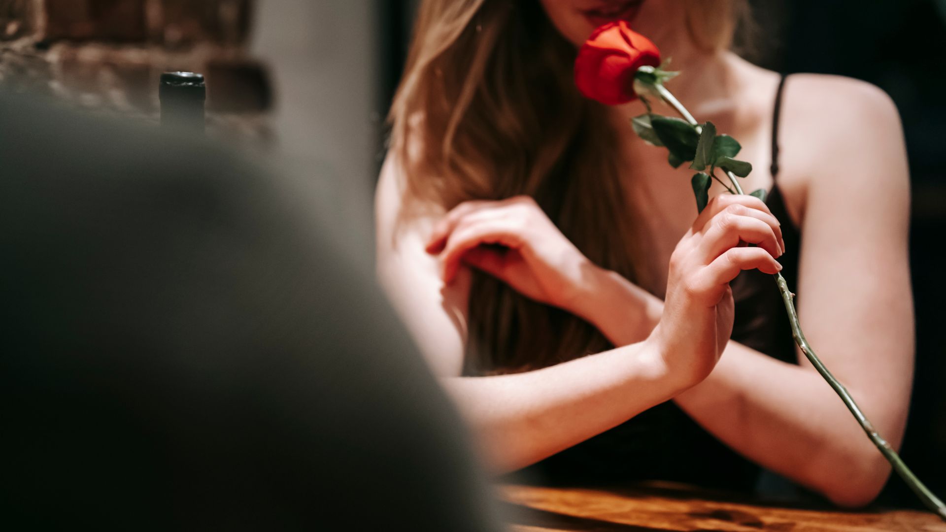Imagem de uma mulher segurando uma rosa vermelha que recebeu