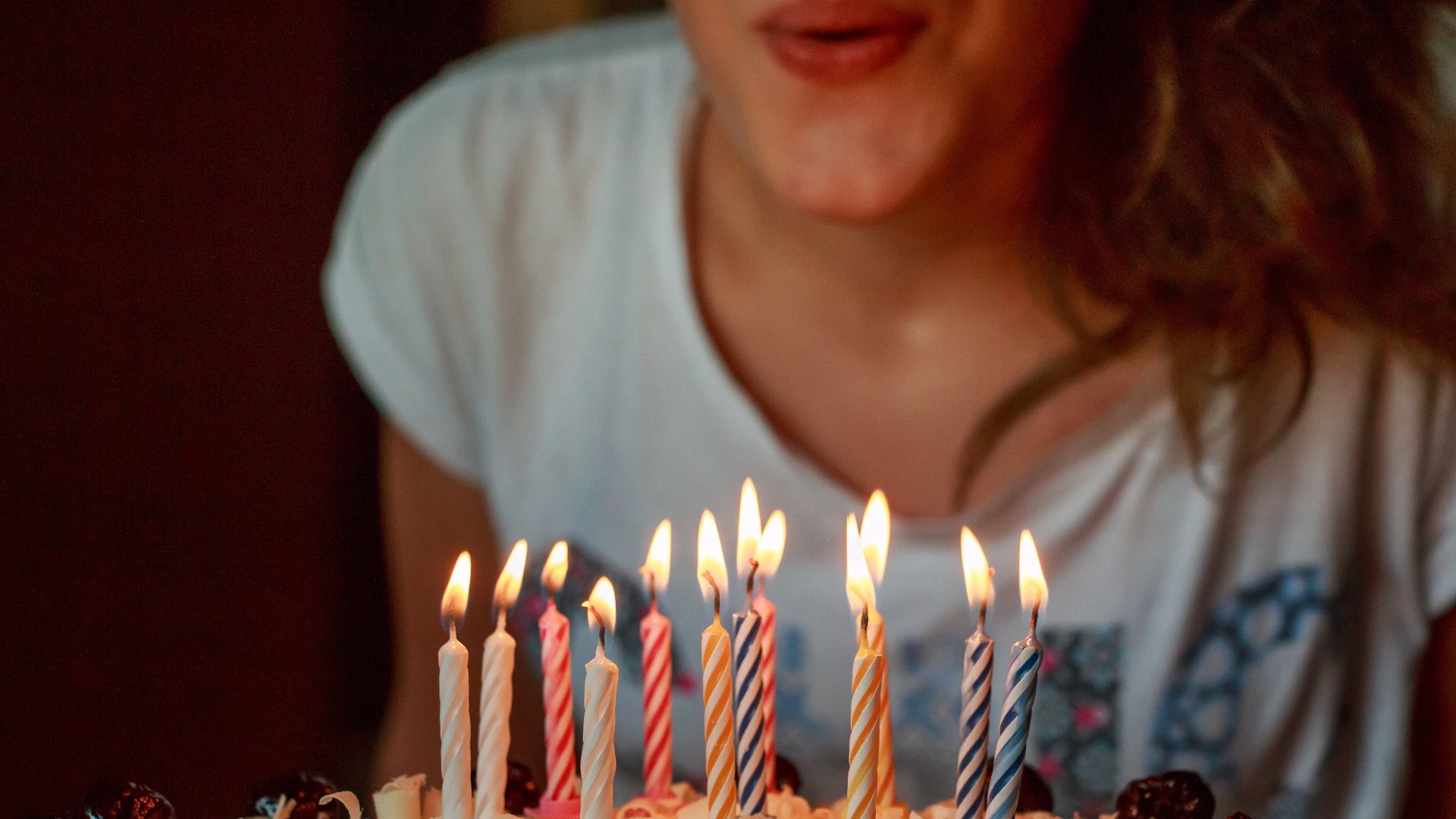Mulher assoprando velas de bolo de aniversário