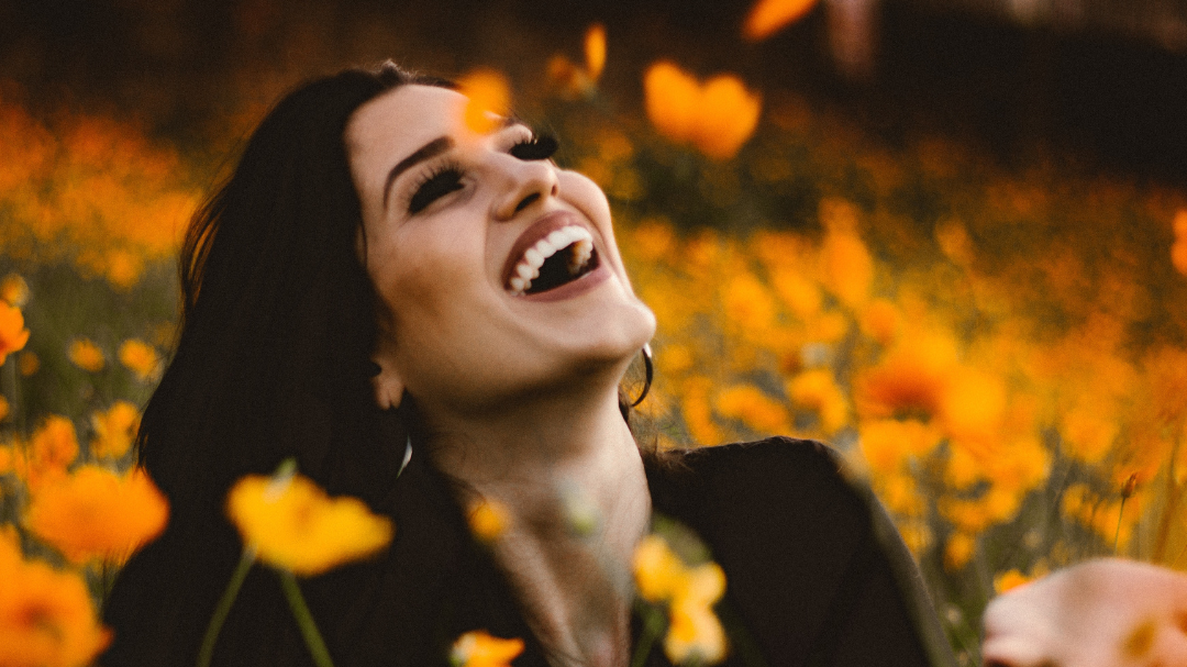 Mulher sorrindo em meio a flores