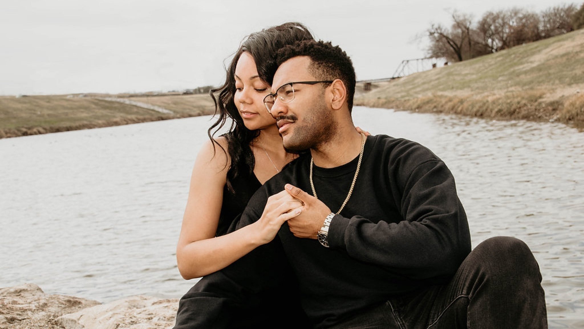 Homem e mulher abraçados em frente a um lago