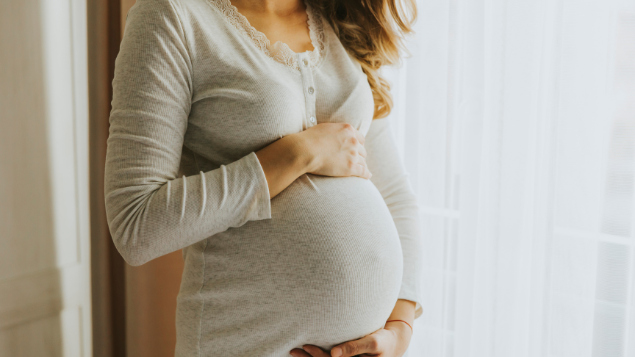 Mulher acaraciando a barriga grávida