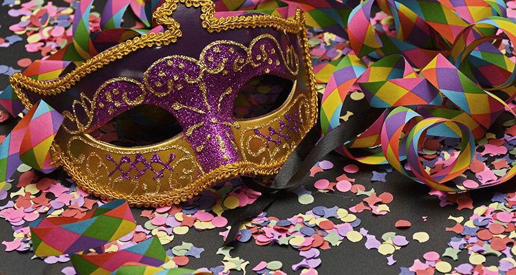 Máscara carnavalesca, cercada de confete e fitas coloridas.