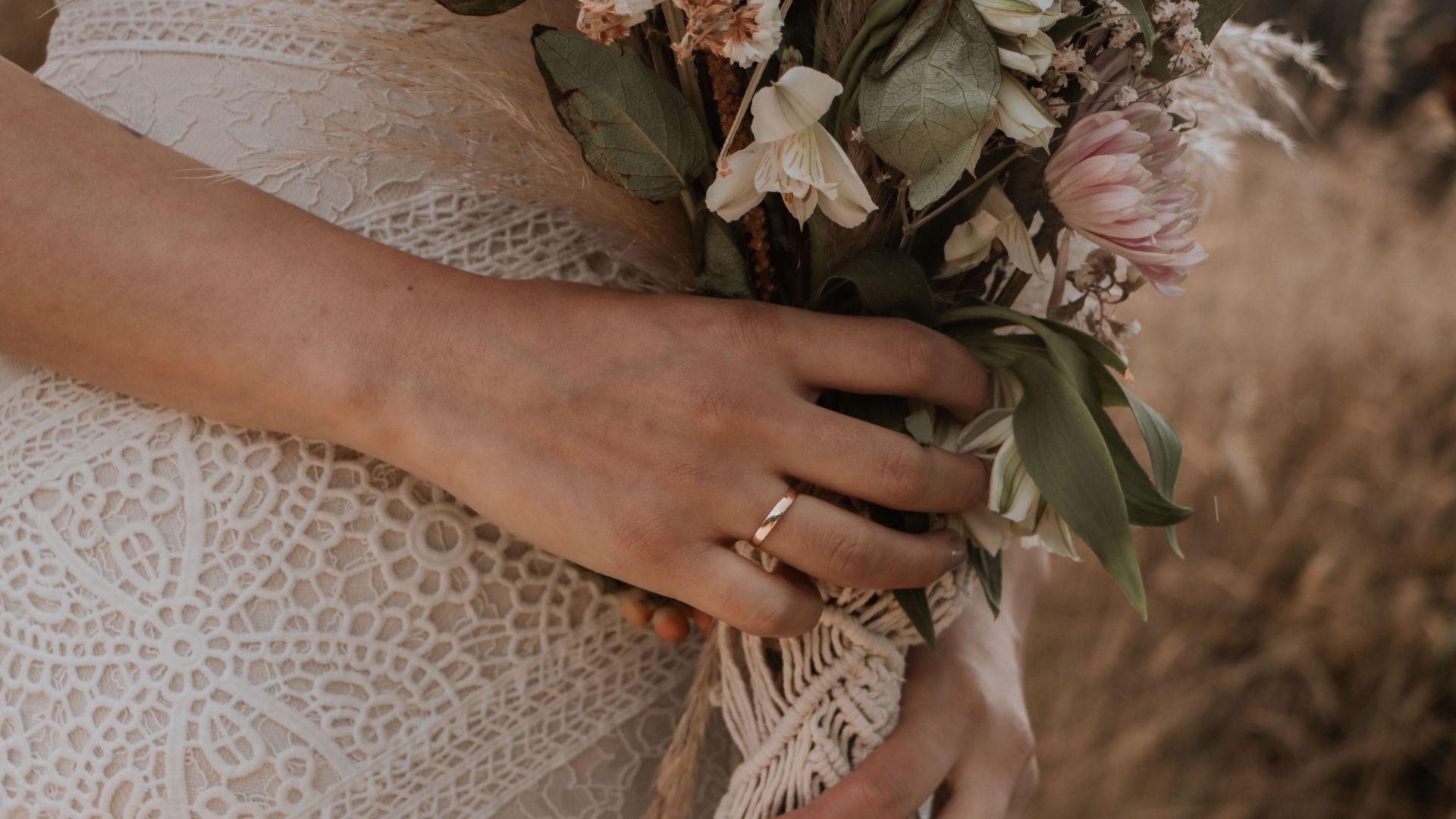 Imagem de uma noiva segurando um lindo buquê de flores.