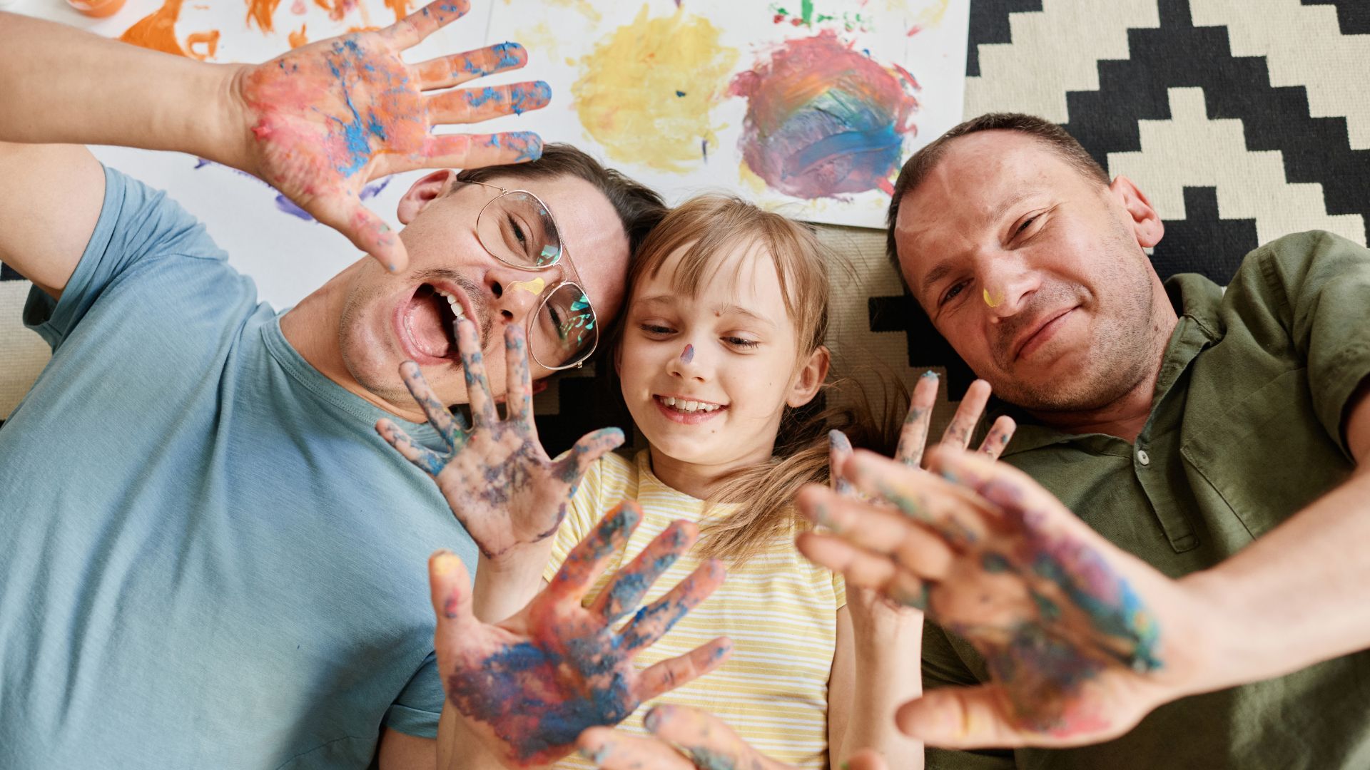Imagem de uma família com as mãos pintadas de colorido
