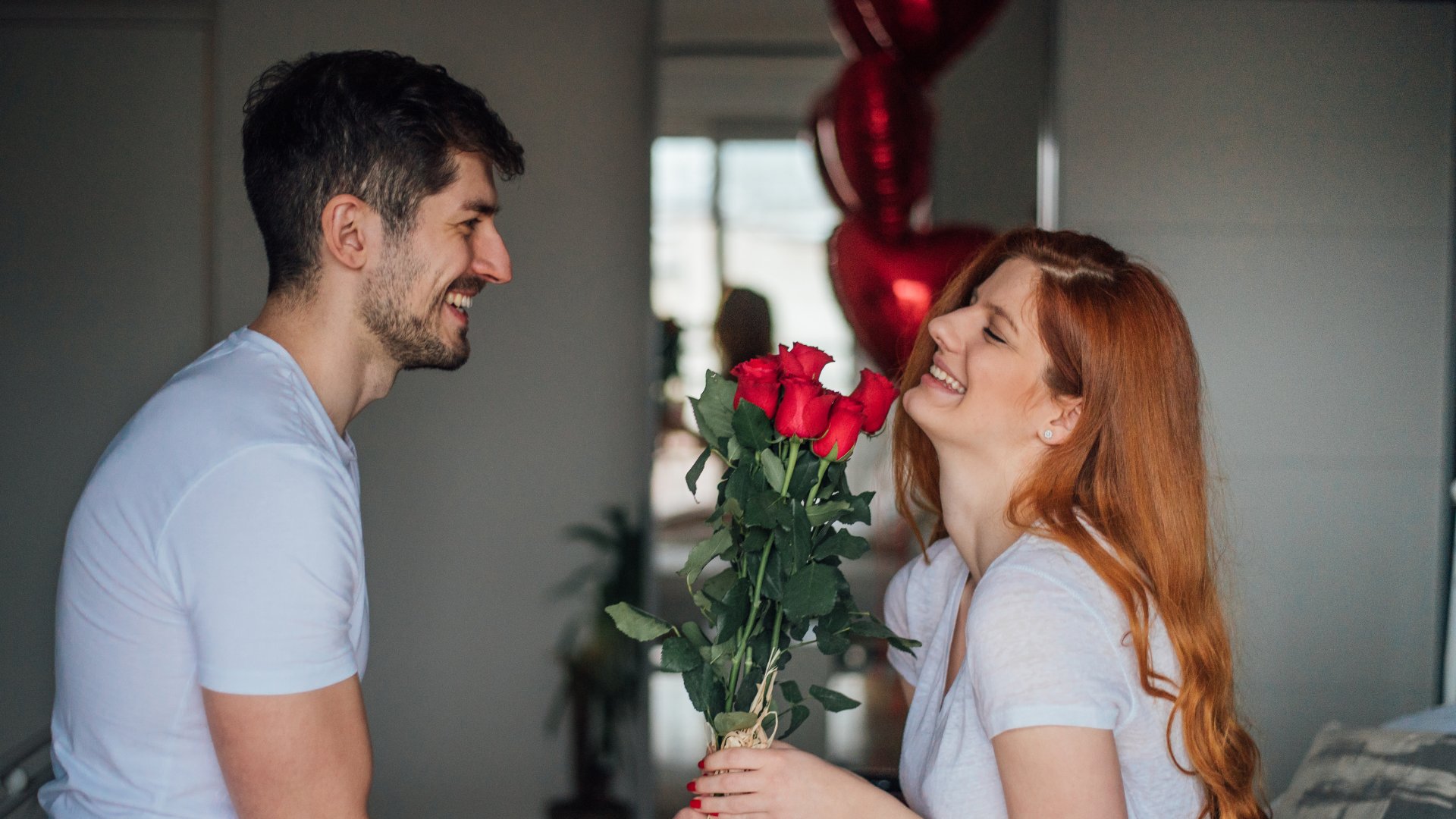 Homem dando rosas vermelhas para uma mulher