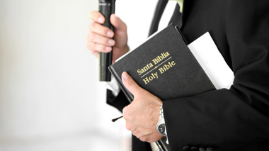 Pastor segurando um microfone e uma bíblia