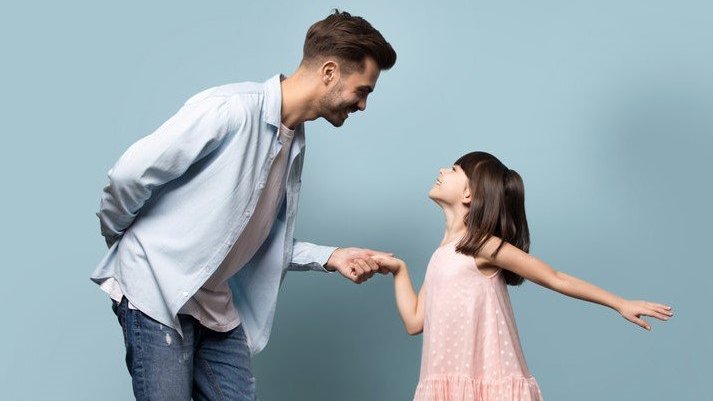 Homem branco segurando mão de menina branca.