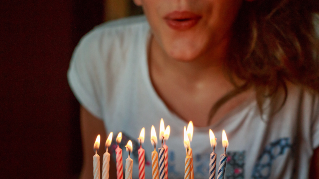 Mulher assoprando velinhas de aniversário