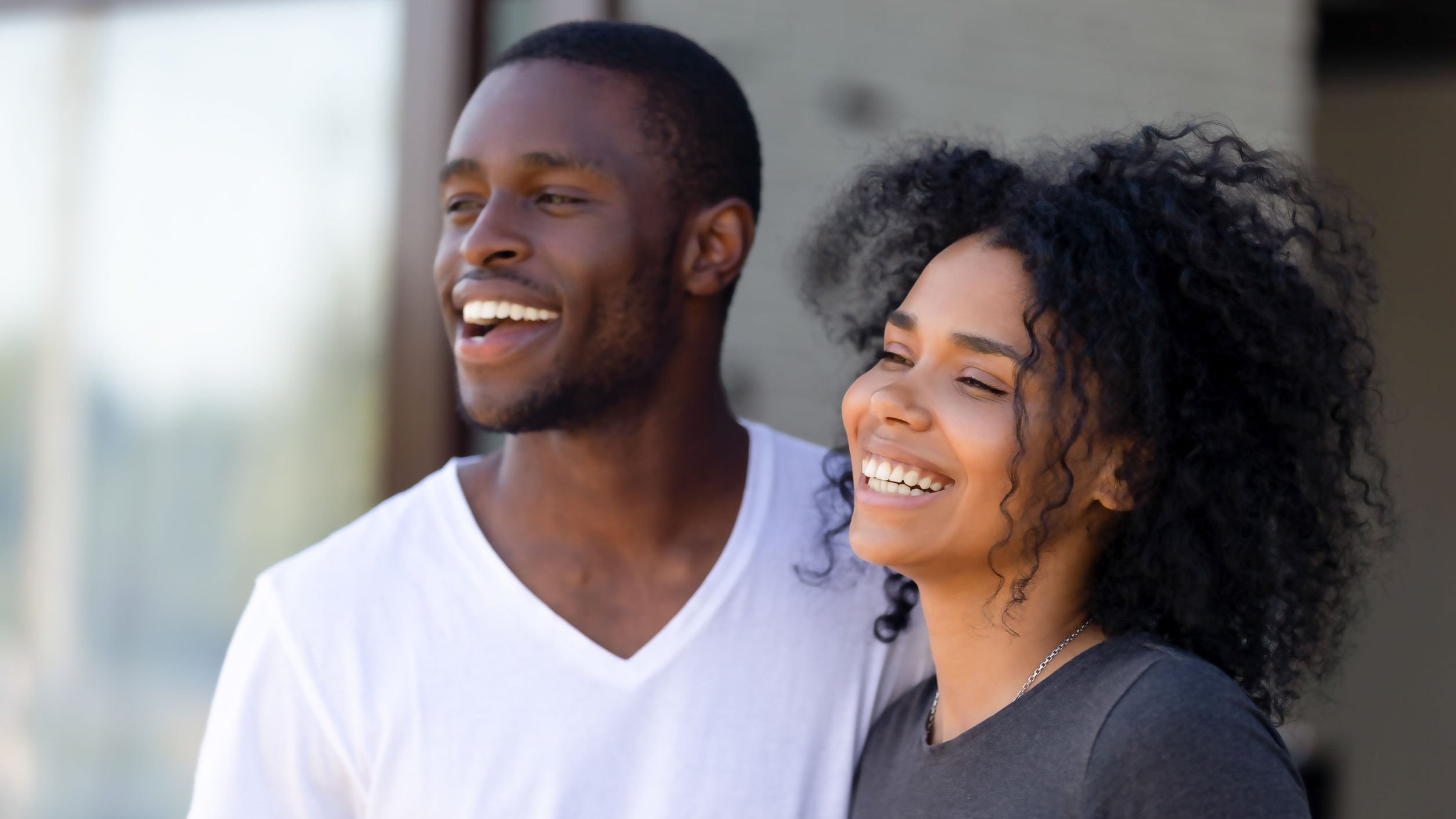 Casal sorrindo olhando para o lado