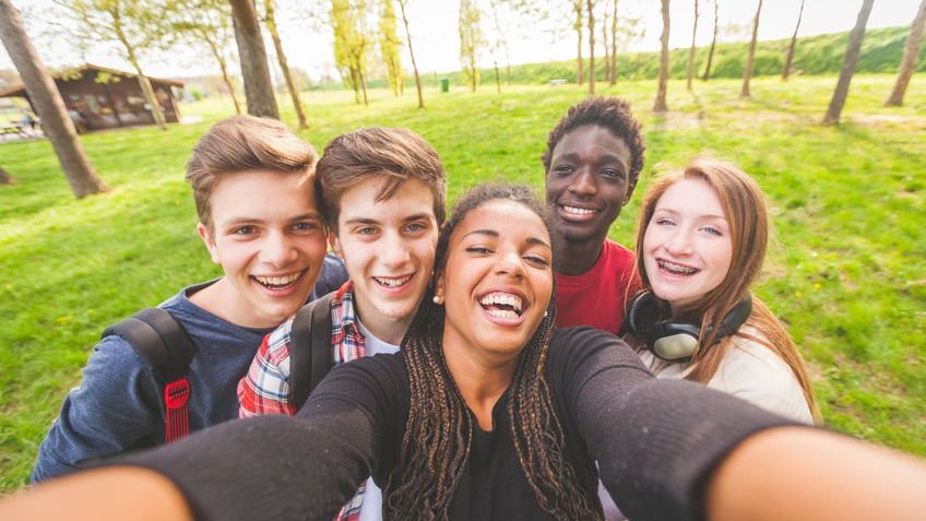Grupo de adolescentes fazendo uma selfie no parque.