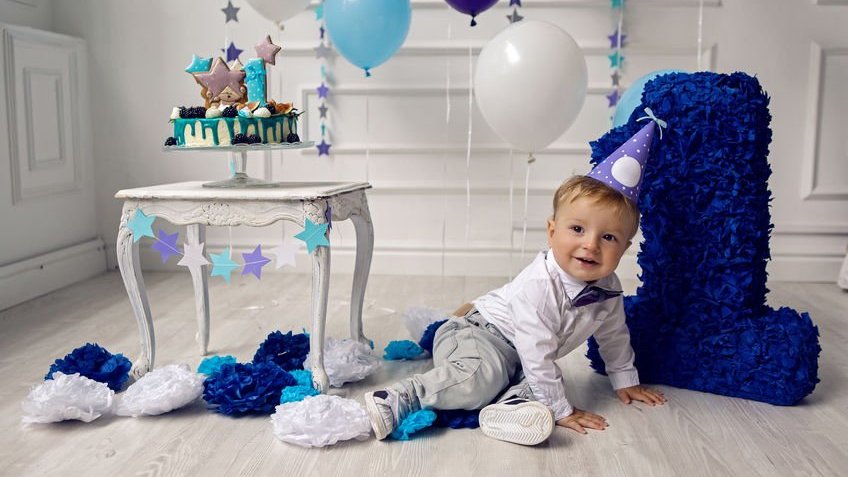 Bebê sorrindo em meio decoração de aniversário de 1 ano