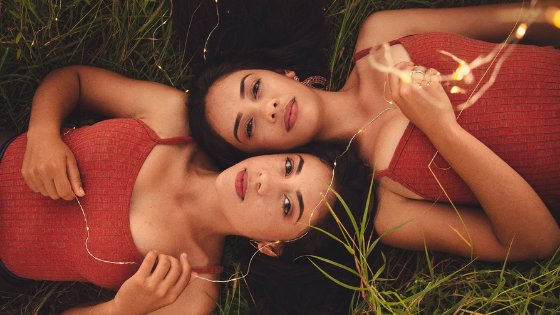 Irmãs gêmeas deitadas em um gramado