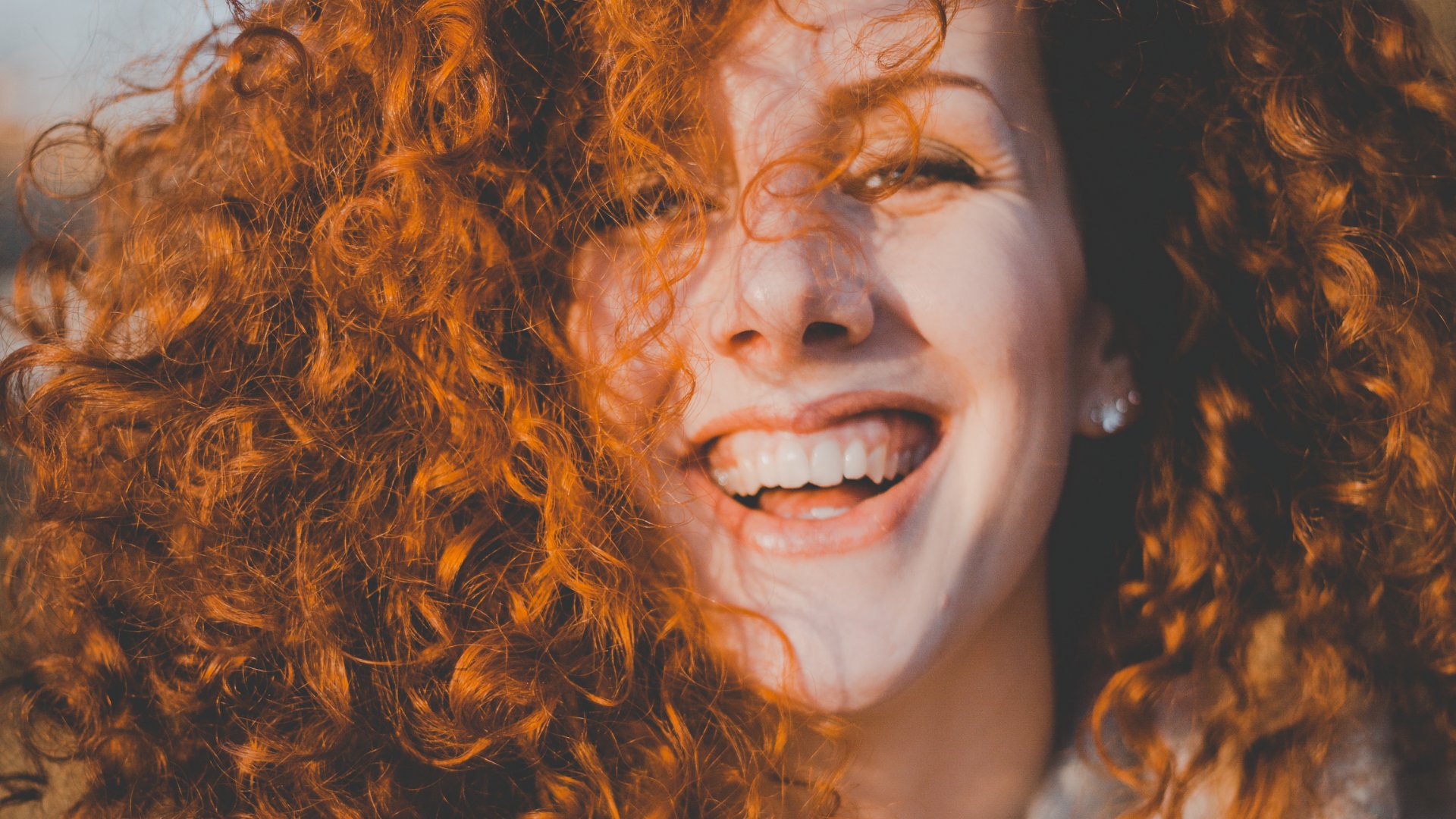 Oleg Magni / Pexels / Canva Mulher ruiva sorrindo