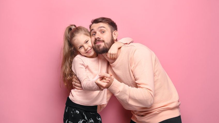 Pai e filha abraçados usando pijamas iguais