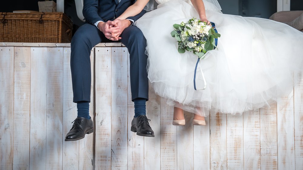 Noivo e noiva sentados em um estrutura de madeira