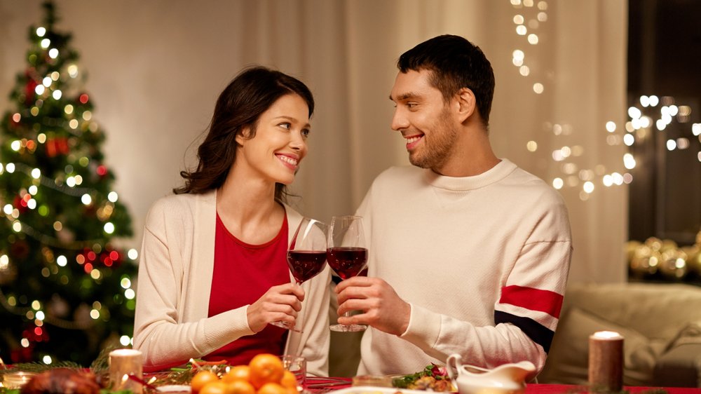 Casal jantando e brindando com vinho