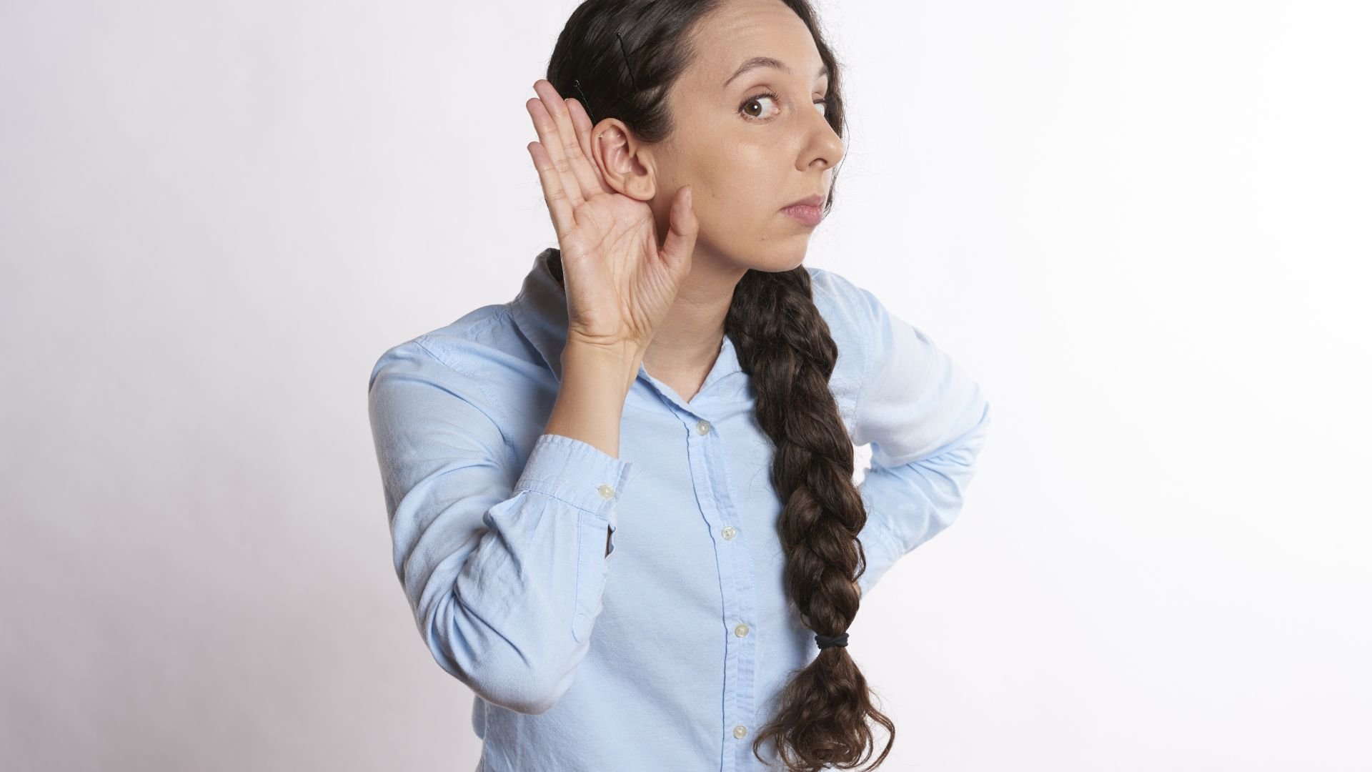 Imagem de uma mulher usando uma camisa azul clara e com uma trança no cabelo.