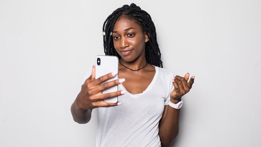 Mulher com celular na mão tirando selfie