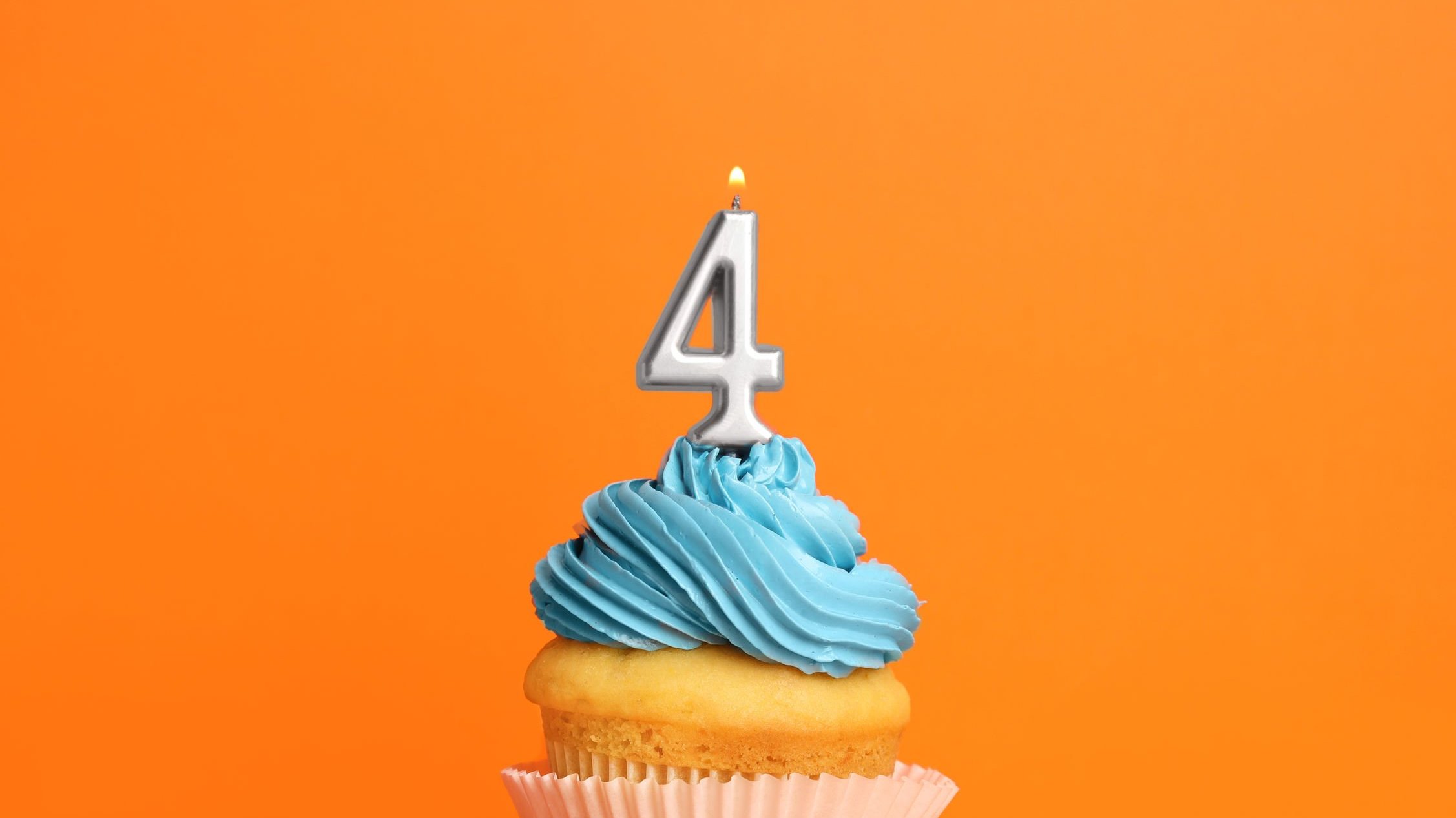 Cupcake com cobertura azul e vela com o número 4.