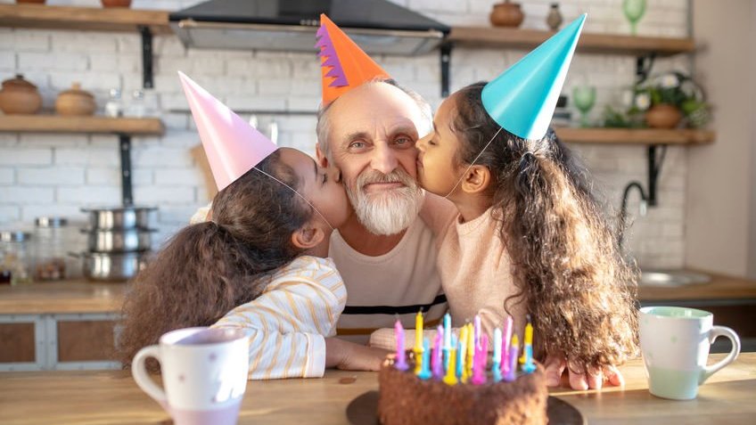 dmytro / 123RF Duas meninas beijando um homem mais velho nas bochechas comemorando aniversário