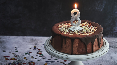 GMVozd / Getty Images Signature Bolo de chocolate com uma vela com o número 8 acesa