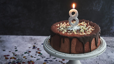 Bolo de chocolate com uma vela com o número 8 acesa