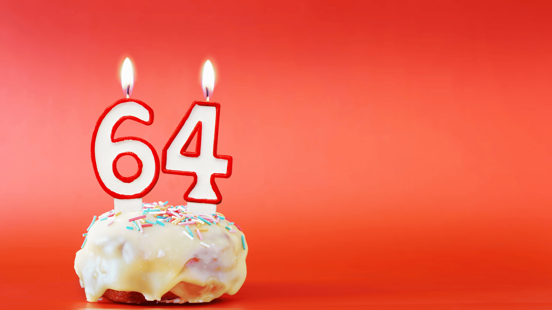 Aniversário de sessenta e quatro anos. Cupcake com vela acesa branca em forma de número 64