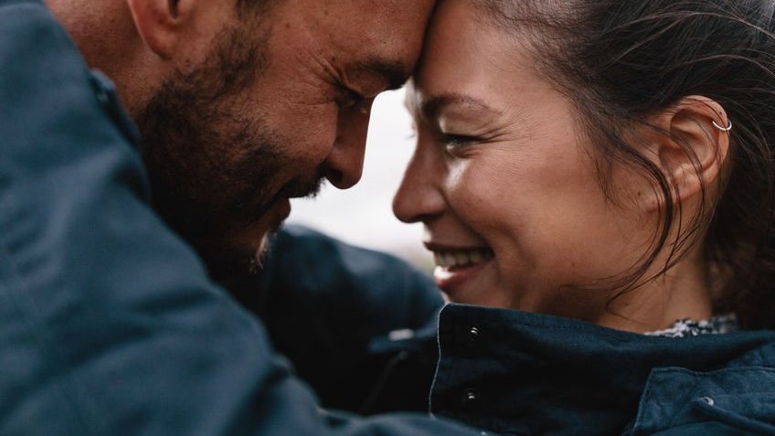 Casal se abraçando e sorrindo