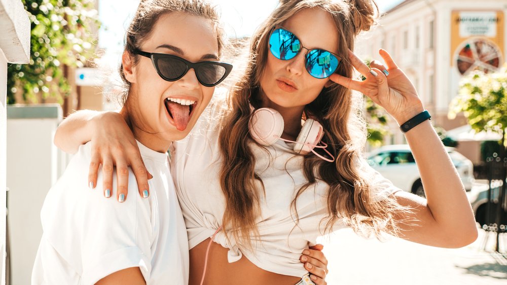 Dupla de amigas posando para foto com óculos escuros