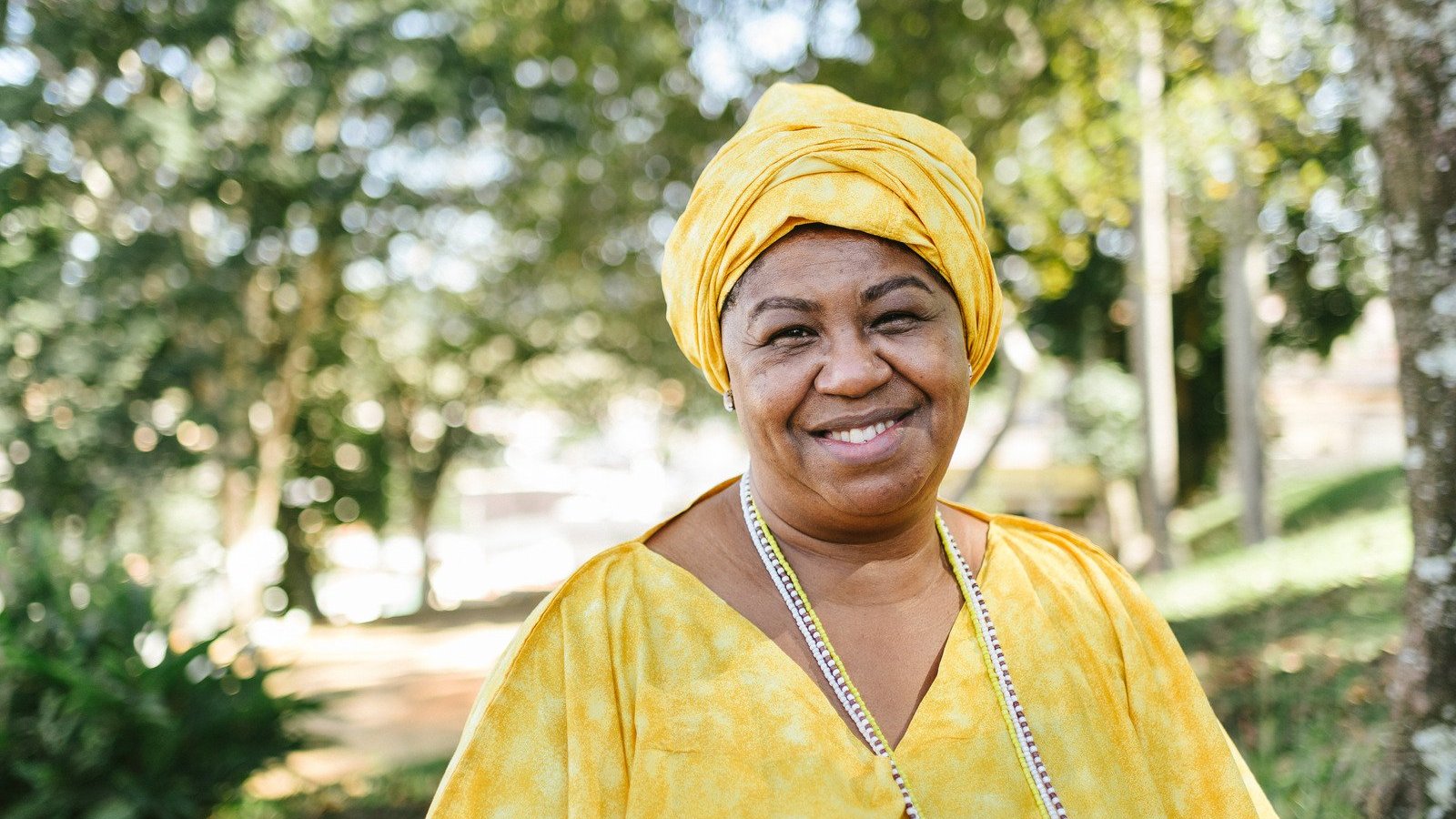 Mulher negra com roupas amarelas características do candomblé.