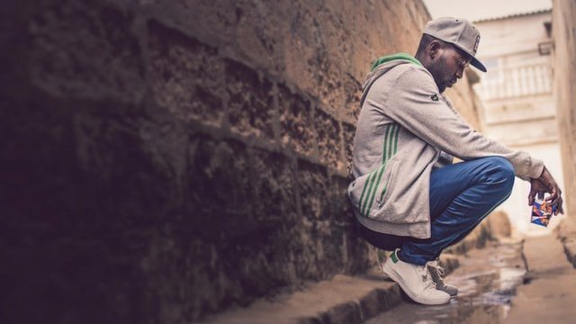 Unsplash / Olhar Angolano Homem agachado na rua