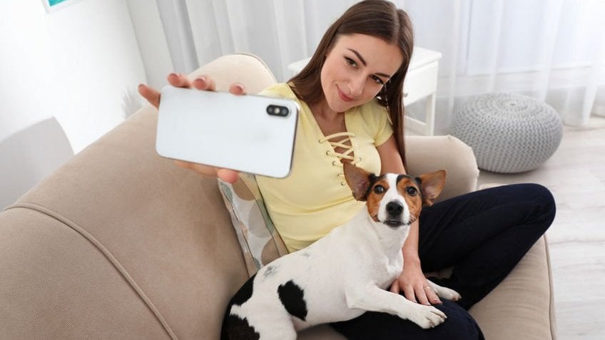 Mulher tirando selfie com o cachorro