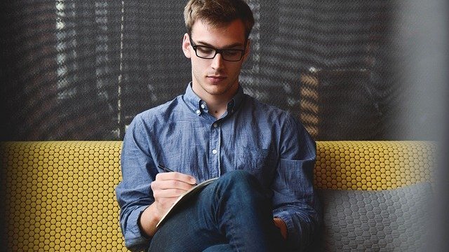 Unsplash / StartupStockPhotos Homem sentando com folha de papel no colo