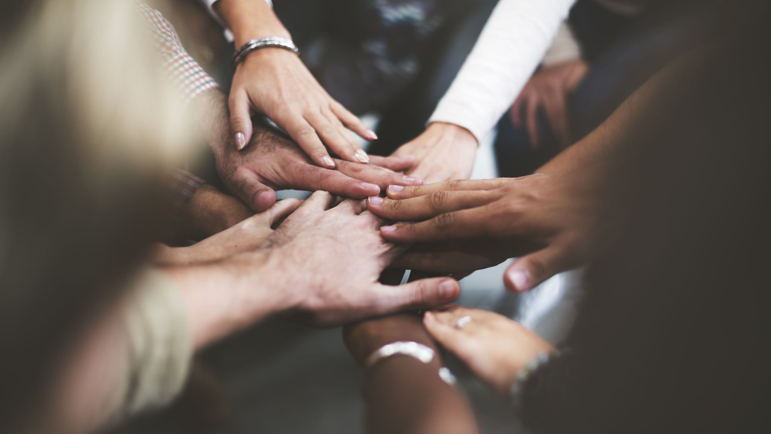 Pessoas com as mãos unidas no centro rawpixel/123RF