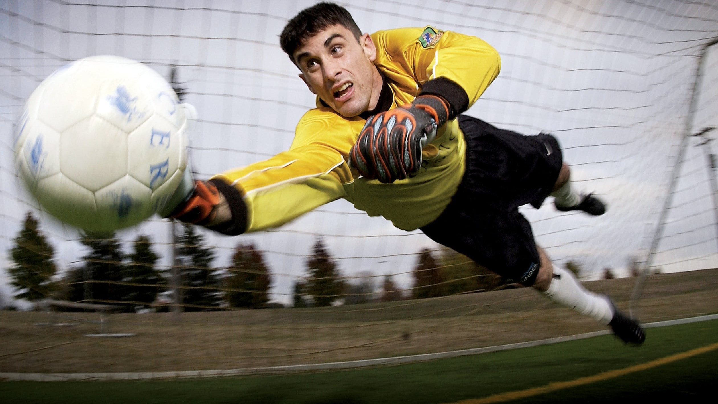 Goleiro de futebol defendendo uma bola