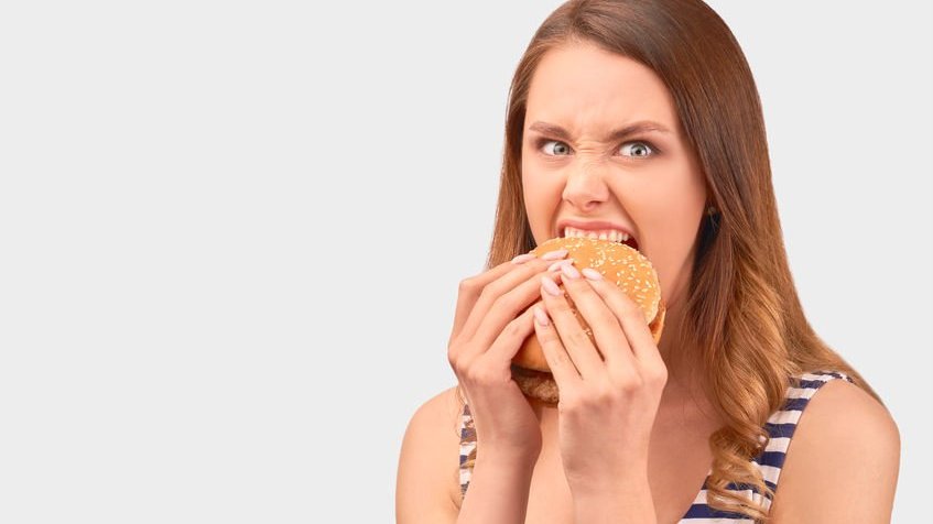 Mulher comendo um hamburguer