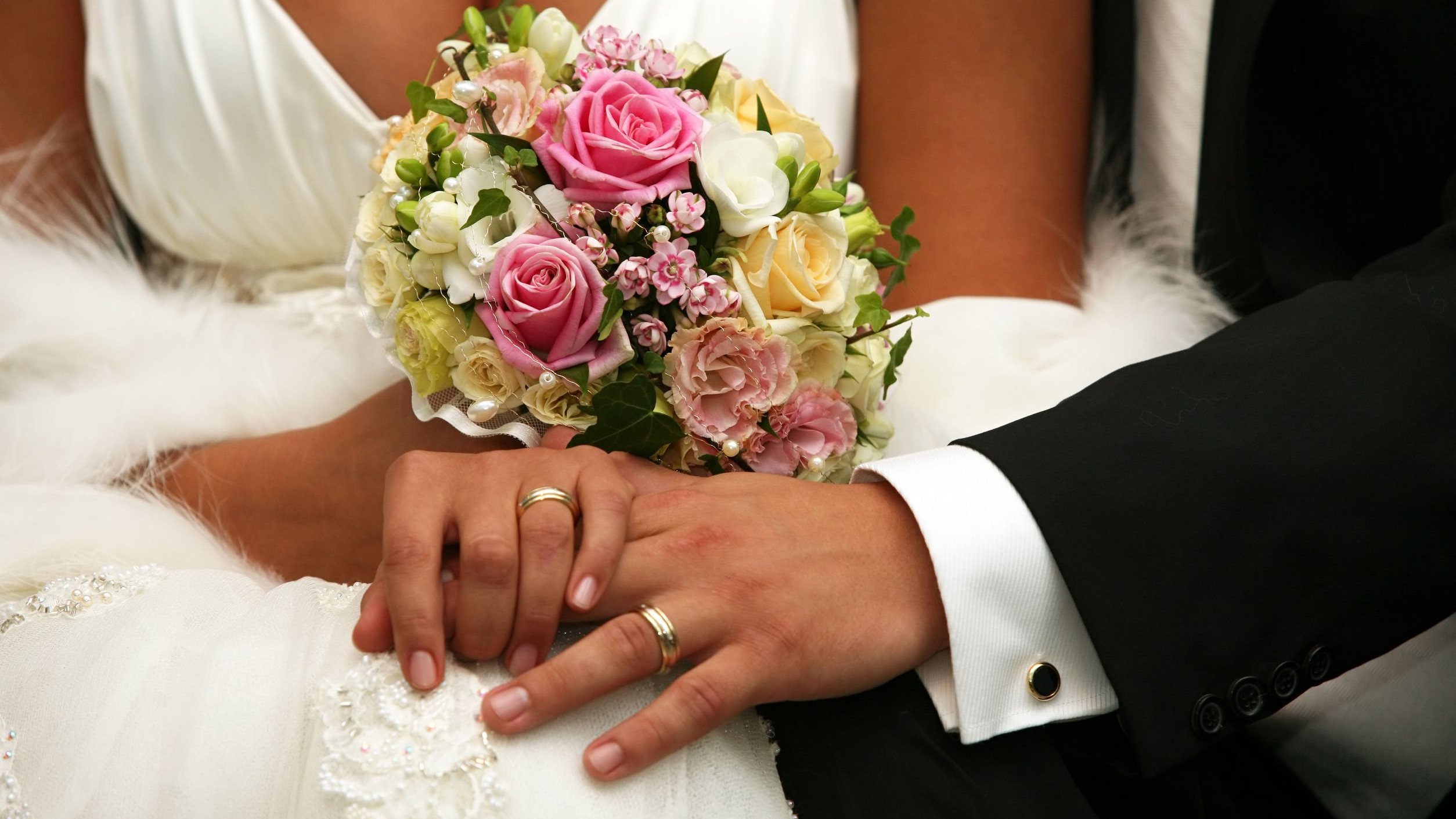 Mãos de noivos com alianças