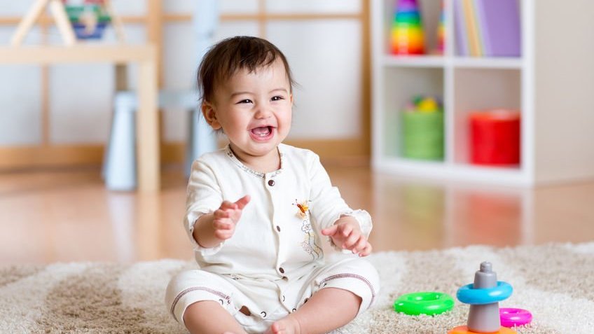 Criança sorrindo e brinquedos ao redor