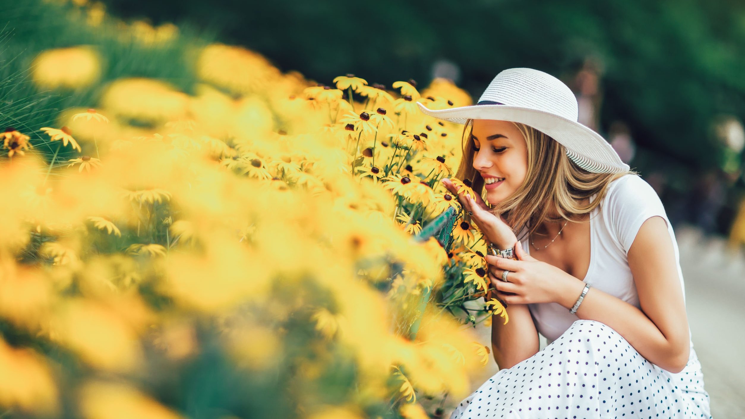 Mulher abaixada em um canteiro de flores